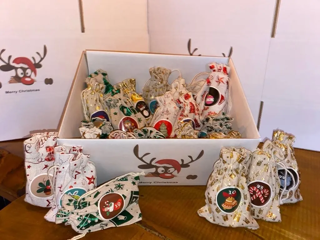Adventskalender der Gin Chilla Bar: weiße Box mit Rentier-Motiv und nummerierten Stoffsäckchen